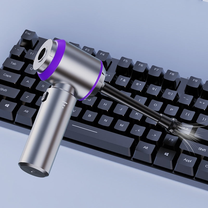 Portable air blower removing dust from computer keyboard